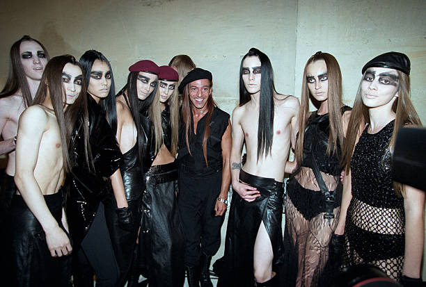 Dior By John Galliano - Couture Collection Fall Winter 1999-2000. Le 19 juillet 1999, dans la cadre de la présentation de la Collection haute couture Automne- Hiver, 1999-2000 de Christian DIOR par John GALLIANO à l'Orangerie du château de Versailles. ici le styliste posant avec un groupe de jeunes mannequins androgynes, dont certains sont des hommes torse nu, portant un maquillage épais et charbonneux de longs cheveux lisses, trois filles portent des bérets. (Photo by Jean-Claude Deutsch/Paris Match via Getty Images)