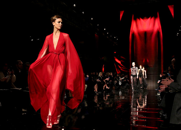 A model wears a flowing red gown in Donna Karan's Fall 2014 runway presentation