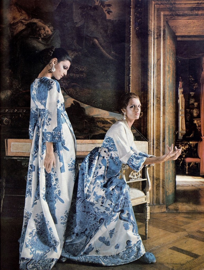 Two models, one standing and the other seated, in Valentino haute couture, in a Roman palazzo with a painting in the background